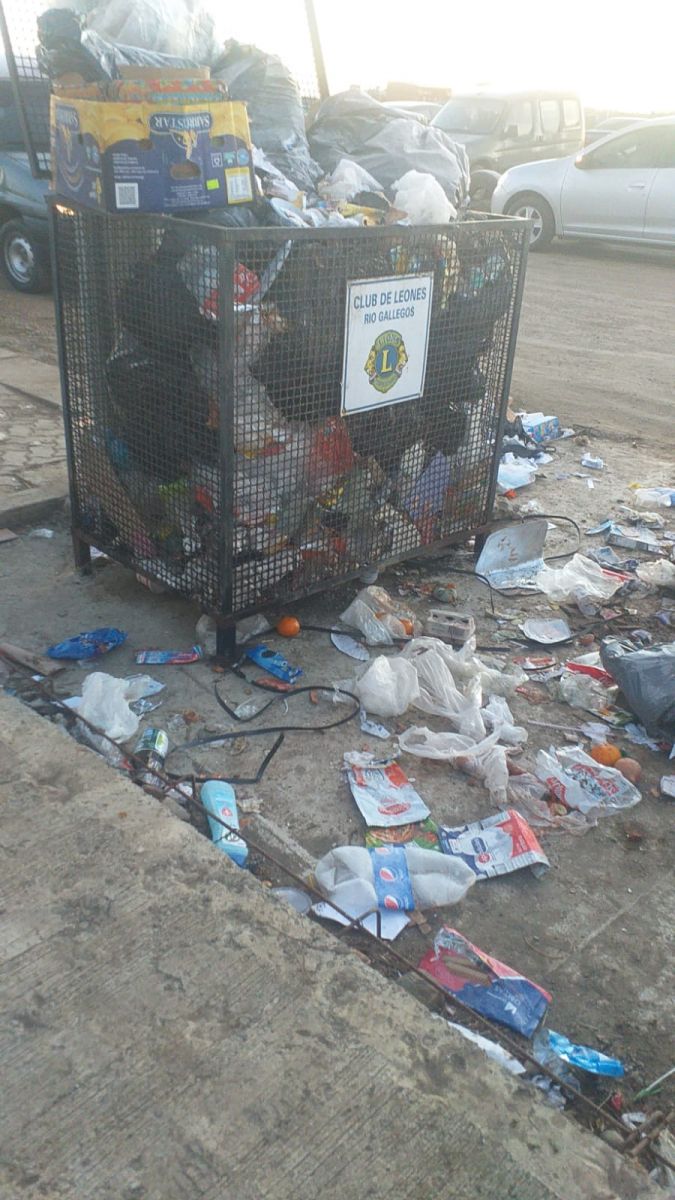 Basura alrededor del canasto de basura. 